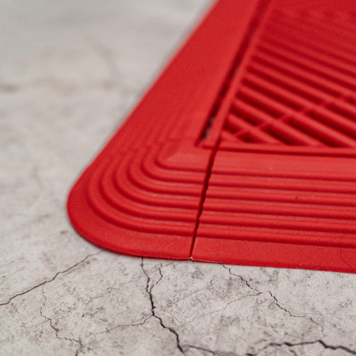 A close up of Racing Red Ribtrax Pro corners and ramps connected to a tile