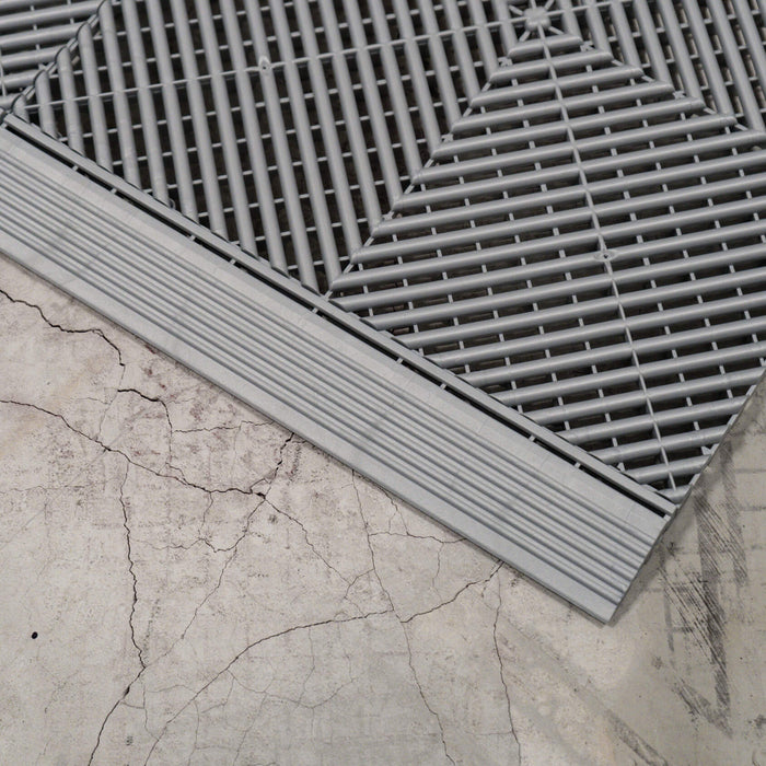 A close up of a Pearl Silver Swisstrax Ribtrax Pro tile connected to a ramp of the same colour