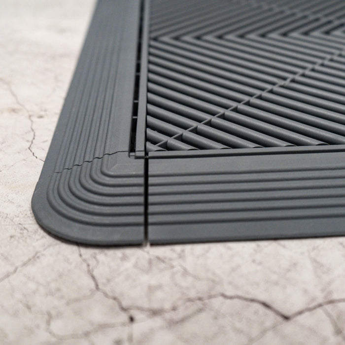 A closeup of a Slate Grey Swisstrax Corner connected to ramps and a tile of the same colour