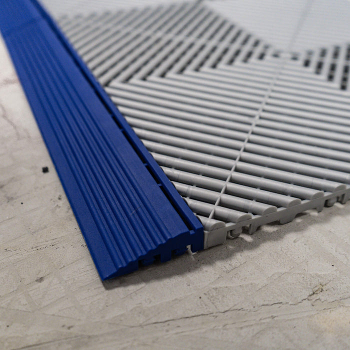 A Swisstrax Royal Blue Ramp connected to a Swisstrax Ribtrax Pro Pearl Silver tile