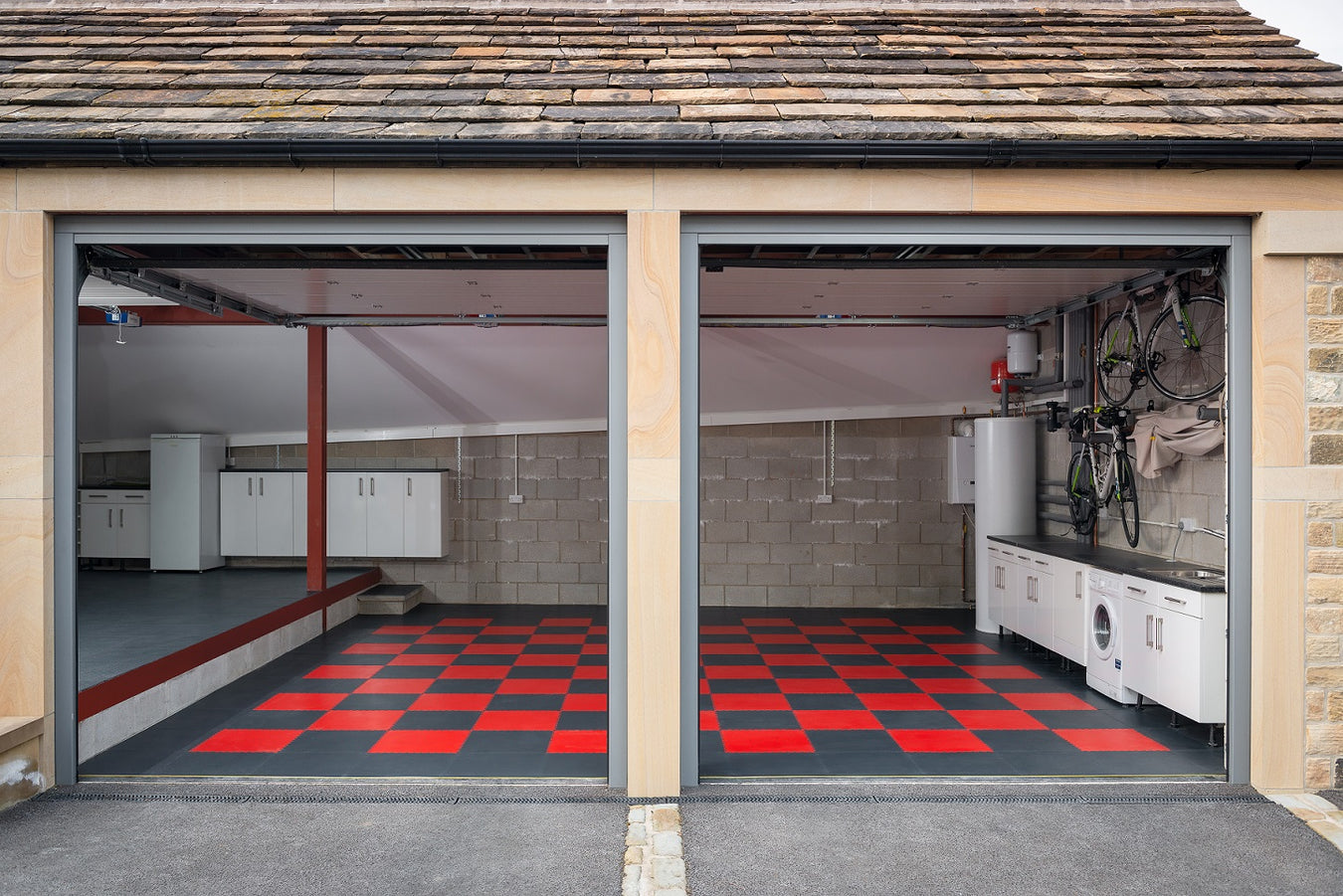 A double garage covered in Red and Graphite interlocking floor tiles from the Garage Floor Tile Company