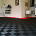 A garage floor with Jet Black Swisstrax Ribtrax Pro tiles in the centre and Racing Red around the outside