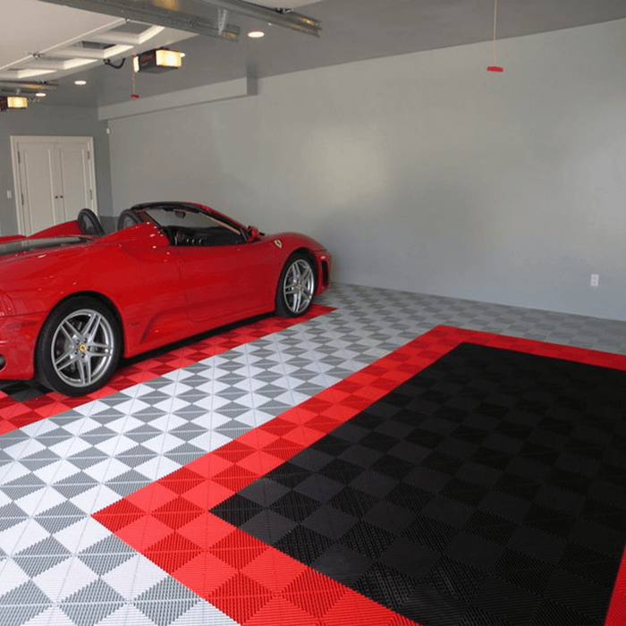 A garage with Pearl Silver, Racing Red and Jet Black Swisstrax Ribtrax Pro tiles on the floor to create two parking spaces for a red car